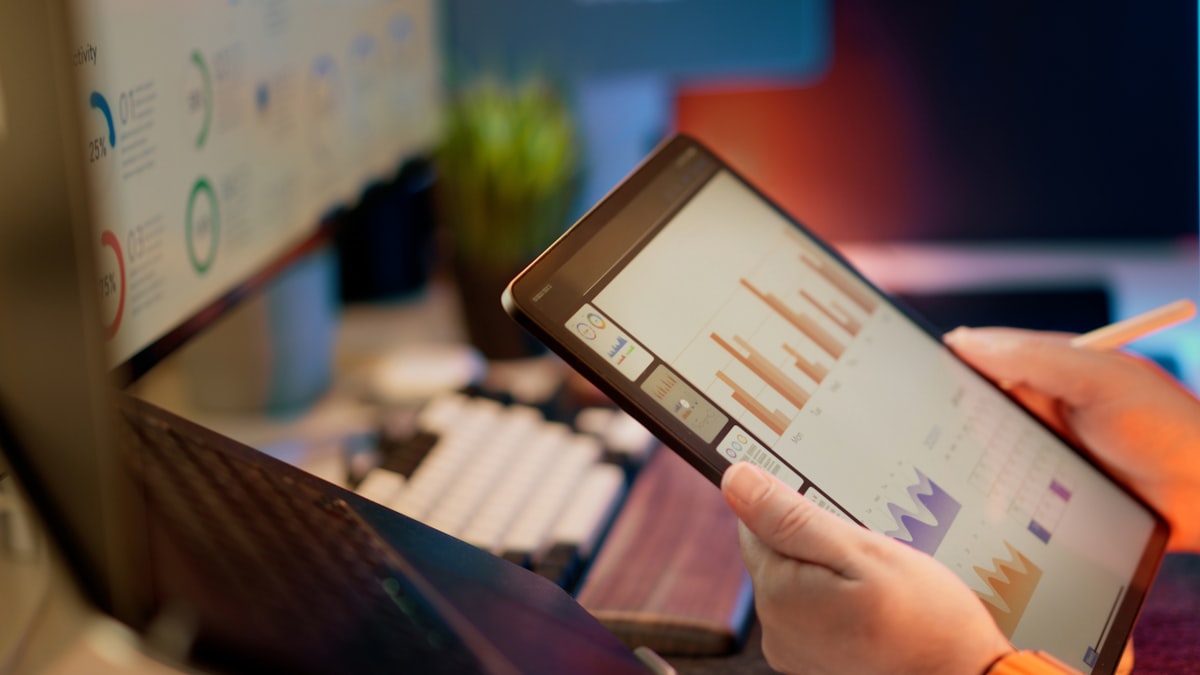Professionista che consulta dati e dashboard su tablet in ufficio
